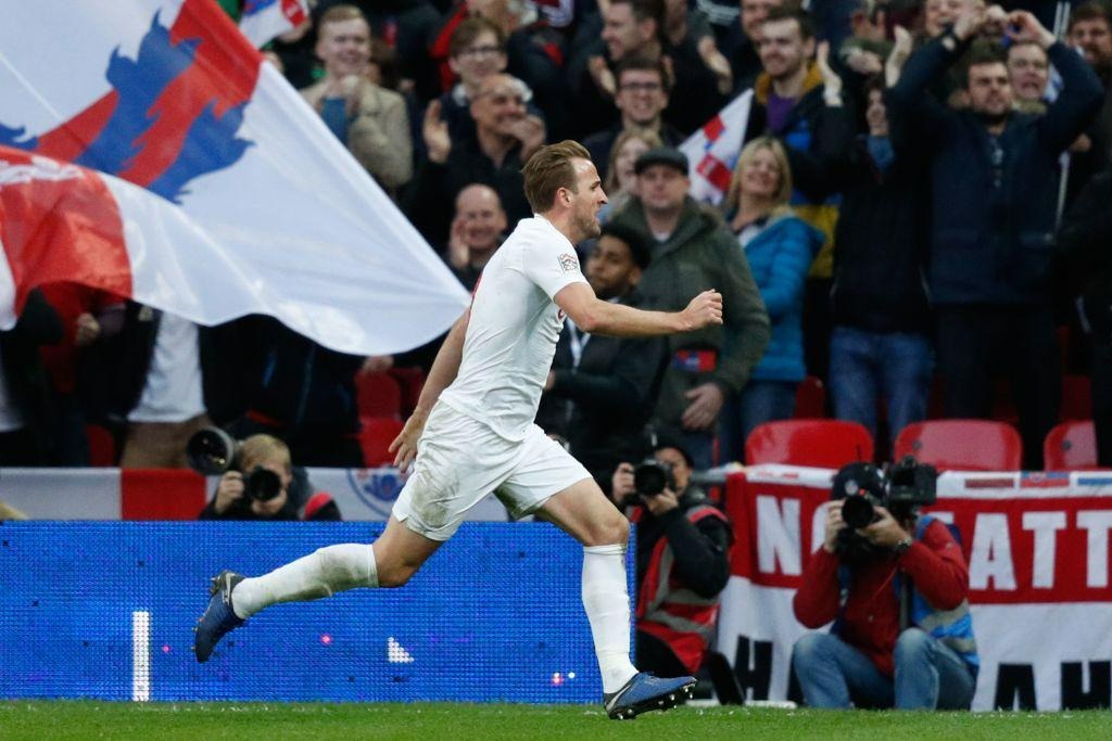 Harry Kane celebrating a goal for England in front of cheering fans during an international football match