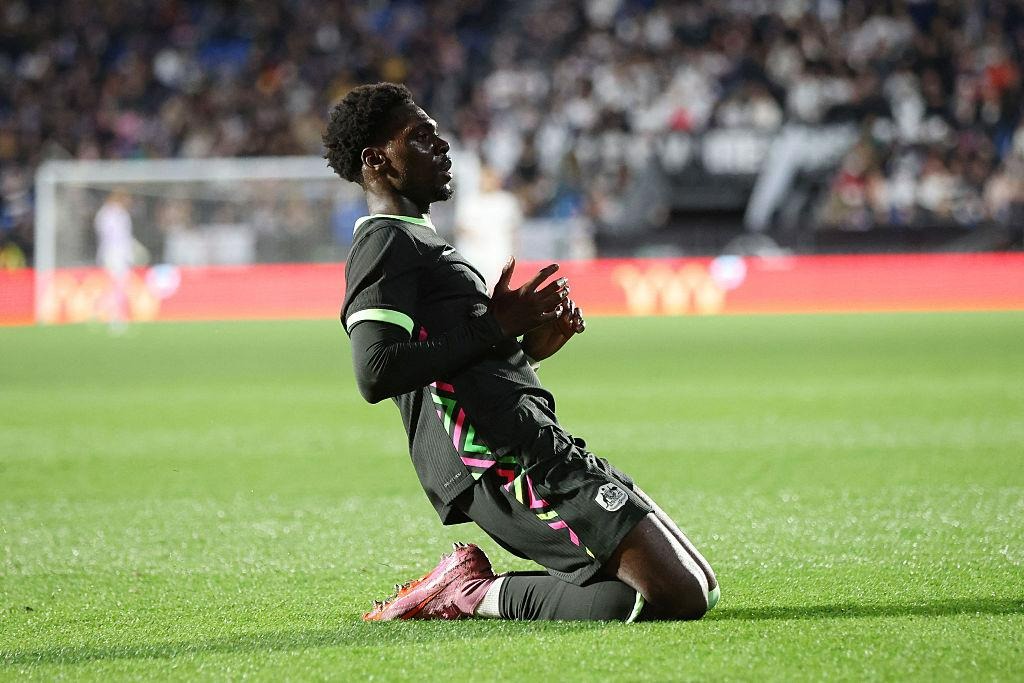 Mohamed Toure celebrating a goal during a football match with a knee-slide celebration