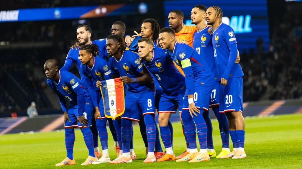 France national football team players in blue kits posing together on the pitch before a match.