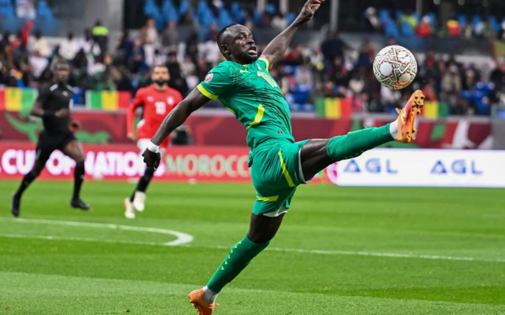 Sadio Mané in Senegal national team kit controlling the ball during a football match.